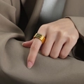 Golden textured band ring featuring three rows of dark crystals on a model's hand - US 6 / Gold with Green Zirconia