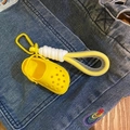 Mini yellow clog shoe keychain with woven rope hook hanging on denim jeans pocket - Dopamine Yellow
