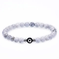 Natural white turquoise bead bracelet featuring a personalized letter Q charm on elastic cord - Letter Q Bracelet