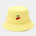 Dettaglio di un cappello a secchiello giallo in cotone con ricamo di ciliegie rosse sul davanti - Ciliegia Giallo