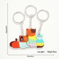 Detalle de tres llaveros de madera de gatos con medidas de 10cm y marca de peso de 18g - Familia de gatos de tres