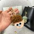 Close-up of a plush doll keychain with brown curly hair and white frame sunglasses - Single OPP Bag Packaging / Orange