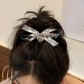 Barrette à cheveux nœud argenté avec pendentif cœur portée sur une queue de cheval - Nœud pour cheveux / Nœud Argenté