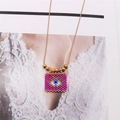 Detail of bohemian evil eye pendant crafted with pink beads on a gold snake chain - Pink