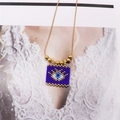 Macro detail of Bohemian evil eye beaded pendant necklace with golden metal accents - Dark Blue