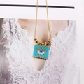 Detail of bohemian evil eye pendant necklace with blue and white seed beads on gold chain - White