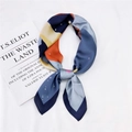 Carré de soie aux motifs abstraits bleu marine et orange posé à plat élégamment - Danse de Salon