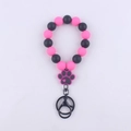 Detail eines Silikonperlen-Armbands in Rosa und Schwarz mit Pfotenabdruck und Schlüsselring - Rosenrot