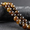 Polished 10mm golden tiger eye stone beads with natural cat-eye effect and texture - Longevity Flower