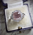 Detail of pink cushion cut moissanite ring set in two-tone gold on a velvet box - US 5 / Pink Cushion/Rose Gold