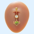 Piercing de nombril doré avec cœur vert en cristal et ailes sur fond bleu clair - Cœur Ailé Vert (#10)