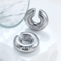 Macro detail of silver C-shape hammered earrings displayed on a white textured stone - Steel Hammered Hollow Ear Clip (MS-198)