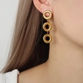 Minimalist triple-loop gold-plated titanium geometric drop earrings worn by a model - Earrings / Gold