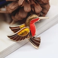 Vibrant enamel hummingbird brooch with red and yellow wings on a golden alloy base - Hummingbird