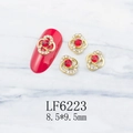 Macro detail of LF6223 flower nail charm with red gemstone and gold alloy base - Gold Flower With Red Stone (6223)