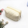 Dettaglio dell'astuccio in peluche bianco crema con motivi a cuore trapuntati - Bianco