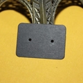 Detail of a black kraft paper earring display card leaning against a metal Eiffel Tower model - 500 Sheets / Black