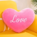 Nahaufnahme eines rosa Plüsch-Herz-Kissens mit weißer Love-Stickerei auf einem Sofa - 15cm / Rosarot