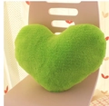 Green heart-shaped plush pillow placed on a lilac chair for romantic gift decor - Green