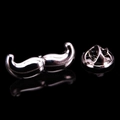 Polished silver mustache brooch pin with butterfly clasp on reflective black surface - Black Mustache
