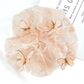 Dettaglio di un elastico in pizzo color crema con ricamo di farfalle 3D e trama fine - Champagne
