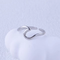 Detail of minimalist wavy stainless steel open ring on a textured artistic background - Steel