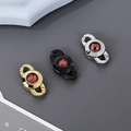 Dettaglio macro di fibbie con pietre rosse in oro, nero e argento in acciaio - Stile Cristallo Rosso 13mm / Oro