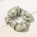 Close-up of light green floral scrunchie with daisy print on bubble crepe fabric - Floral Print Fruit Green
