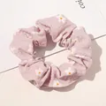 Detailed view of pink floral scrunchie with daisy patterns on seersucker fabric - Floral Print Pink