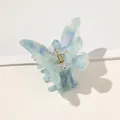 Close-up of light blue marble acetate butterfly hair claw clip with golden metal spring - Milky Blue Butterfly Claw
