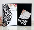 Detail view of a laser-cut black wedding invitation with elegant floral RSVP card and ring - Black