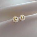 Close-up of titanium earrings featuring centered pearls and sparkling cubic zirconia stones - Stud Earrings (D516)