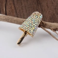Primo piano dettagliato di una spilla a forma di ghiacciolo dorato con strass colorati - Bianco AB