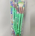 Detailed view of 5 mint green shell makeup brushes with rose gold ferrules in packaging - Green