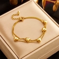 Golden double-layer chain bracelet featuring five heart charms and lobster clasp - Gold