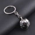 Detailed view of metal football keychain pendant with realistic stitched texture on leather - Half Face Football