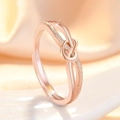 Elegante anillo de nudo en oro rosa con textura mate y grabado S925 sobre tela suave - Oro rosa