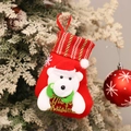 Detalle de calcetín navideño rojo con oso polar colgado en una rama nevada - Oso JOY