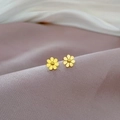 Detail shot of golden floral titanium steel stud earrings on soft textured fabric - Gold (P309金)
