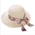 Detail of cream straw sun hat featuring a purple floral ribbon bow on white background - Ribbon Style Milky White