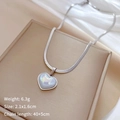 Dettaglio collana a cuore con peso 6,3g e dimensioni 2,1x1,6cm su portagioie beige - Argento