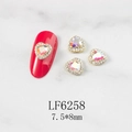 Macro view of heart-shaped AB crystal nail charms with gold trim and 7.5x8mm size specs - Aurora Heart Gold Base (6258)