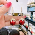 Elegant gold earrings with red pearl drop and zircon crystals on white card - Red