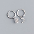 Macro view of asymmetric S925 sterling silver star and moon earrings with pavé zircons - Silver