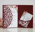 Detail of laser cut burgundy wedding invitation with white card and floral accents - Dark Red