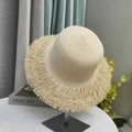 Detailed close-up of straw sun hat with bohemian fringe edge on a display stand - Small / Beige