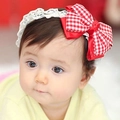 Close-up of baby girl wearing the white lace headband with a red plaid bow - Red Grid