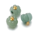 Macro detail of three green aventurine quartz pumpkin pendants with gold loops - Green