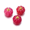 Detailed macro view of three rose red pumpkin-shaped agate crystal pendants with gold loops - Purplish Red