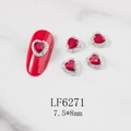 Close-up of heart-shaped red crystal nail gems with rhinestone trim on marble surface - Red Heart Silver Base (6271)